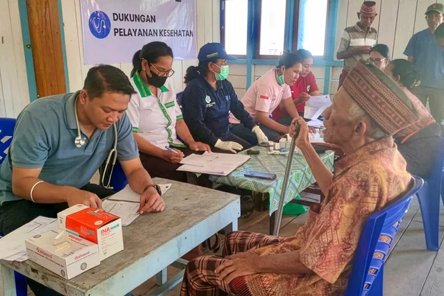 A health worker conducts a checkup for an elderly resident at a community healthcare post