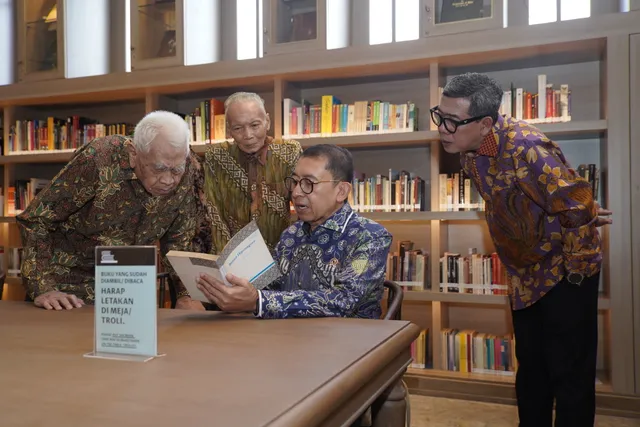 Visitors sitting around a table reading and discussing the Babad Diponegoro book